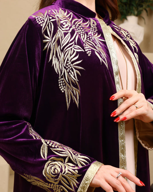 Purple embroidered garment with gold details on a neutral background