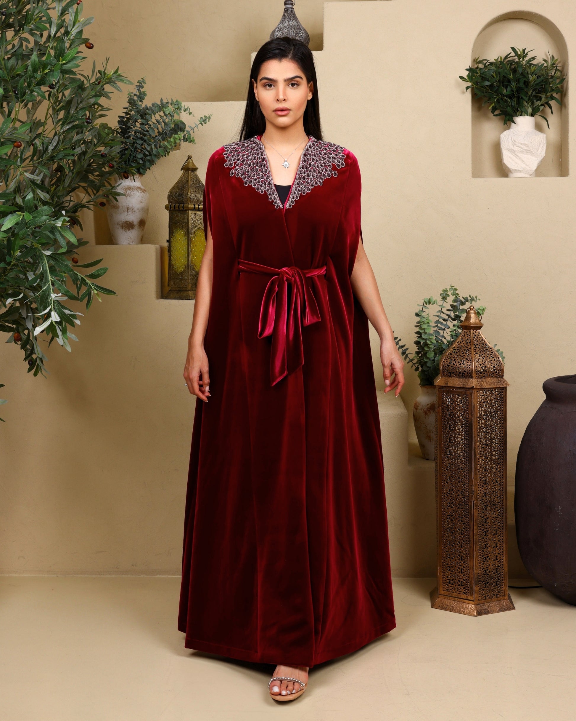 Woman wearing a red dress with a patterned collar in an indoor setting.