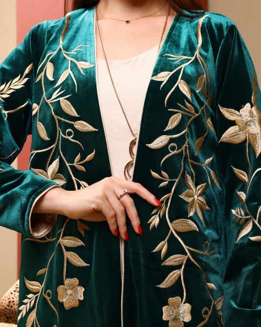Green velvet cardigan with gold embroidery worn by a person.